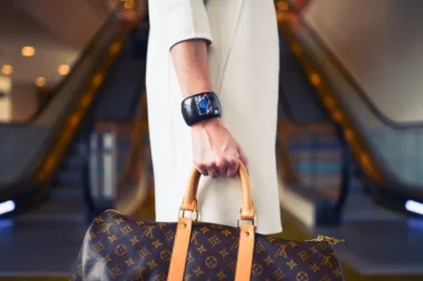 Gros plan sur la main d'une femme tenant un sac de créateur avec une montre-bracelet élégante
