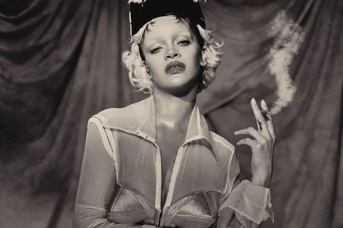 Rihanna en coiffure rétro et soutien-gorge pointu, évoquant Madonna, exhale la fumée d'une cigarette.