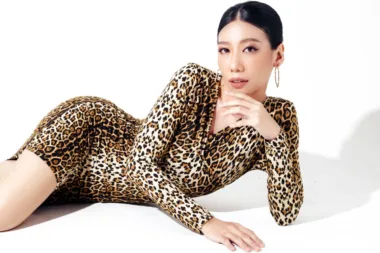Femme élégante allongée portant une combinaison à imprimé léopard.