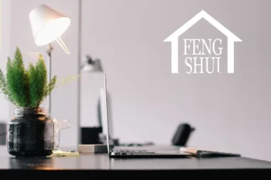 ureau moderne avec ordinateur portable, lampe et plante pour une ambiance Feng Shui.