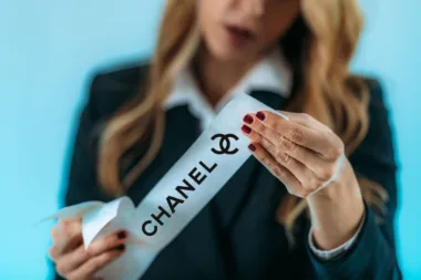 Femme tenant une étiquette avec le logo de Chanel